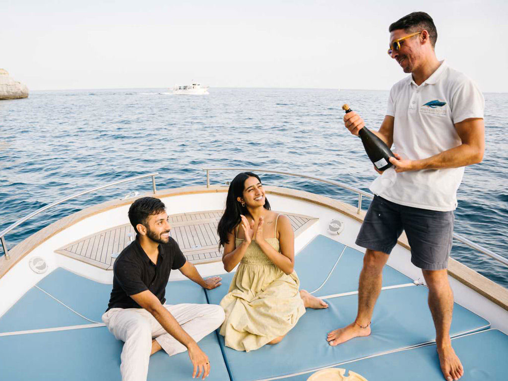 Servendo  prosecco ai turisti durante il tour in barca Amalfi