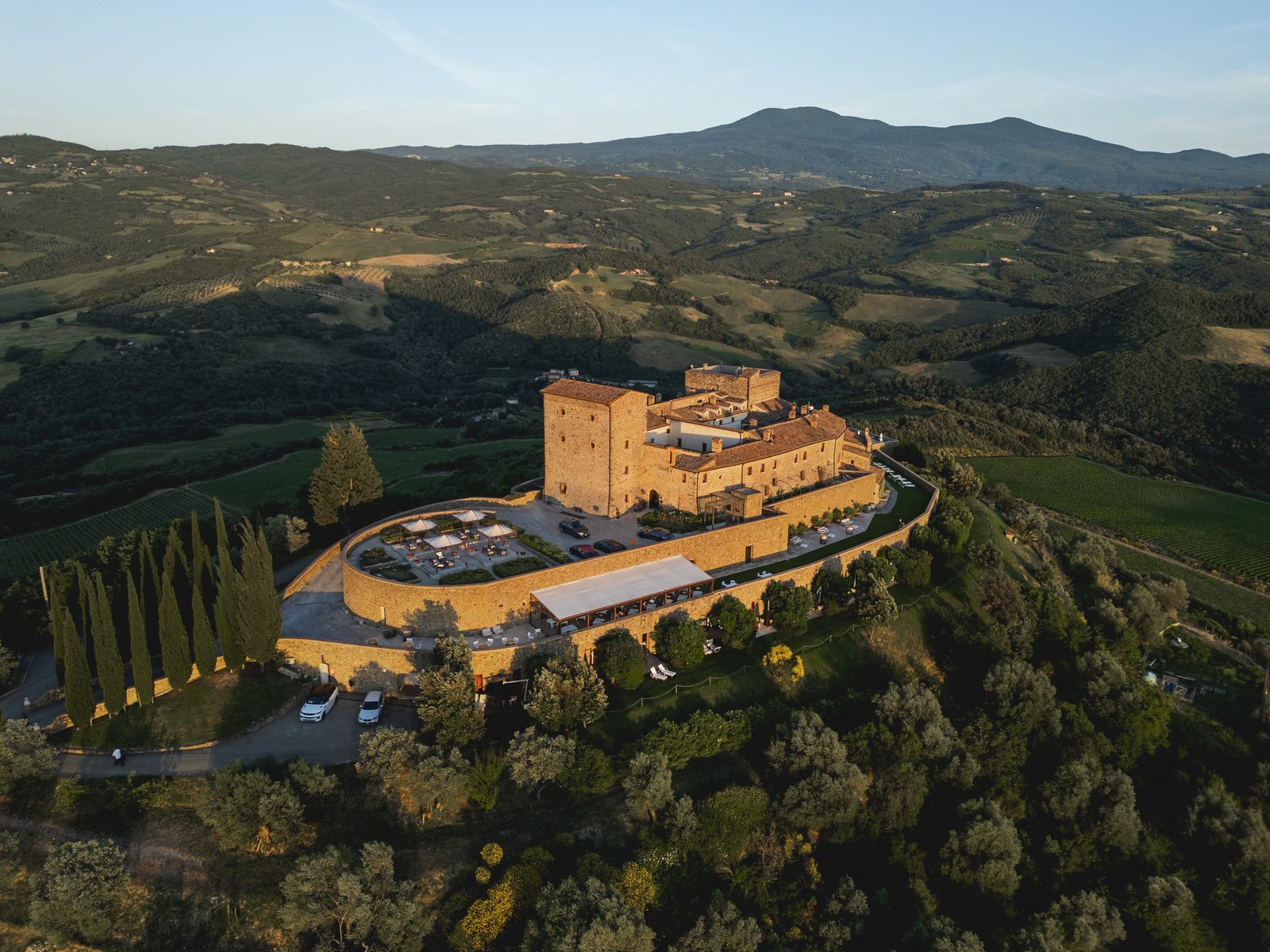 Castello di Velona on its hilltop in the golden light of the Val d&rsquo;Orcia