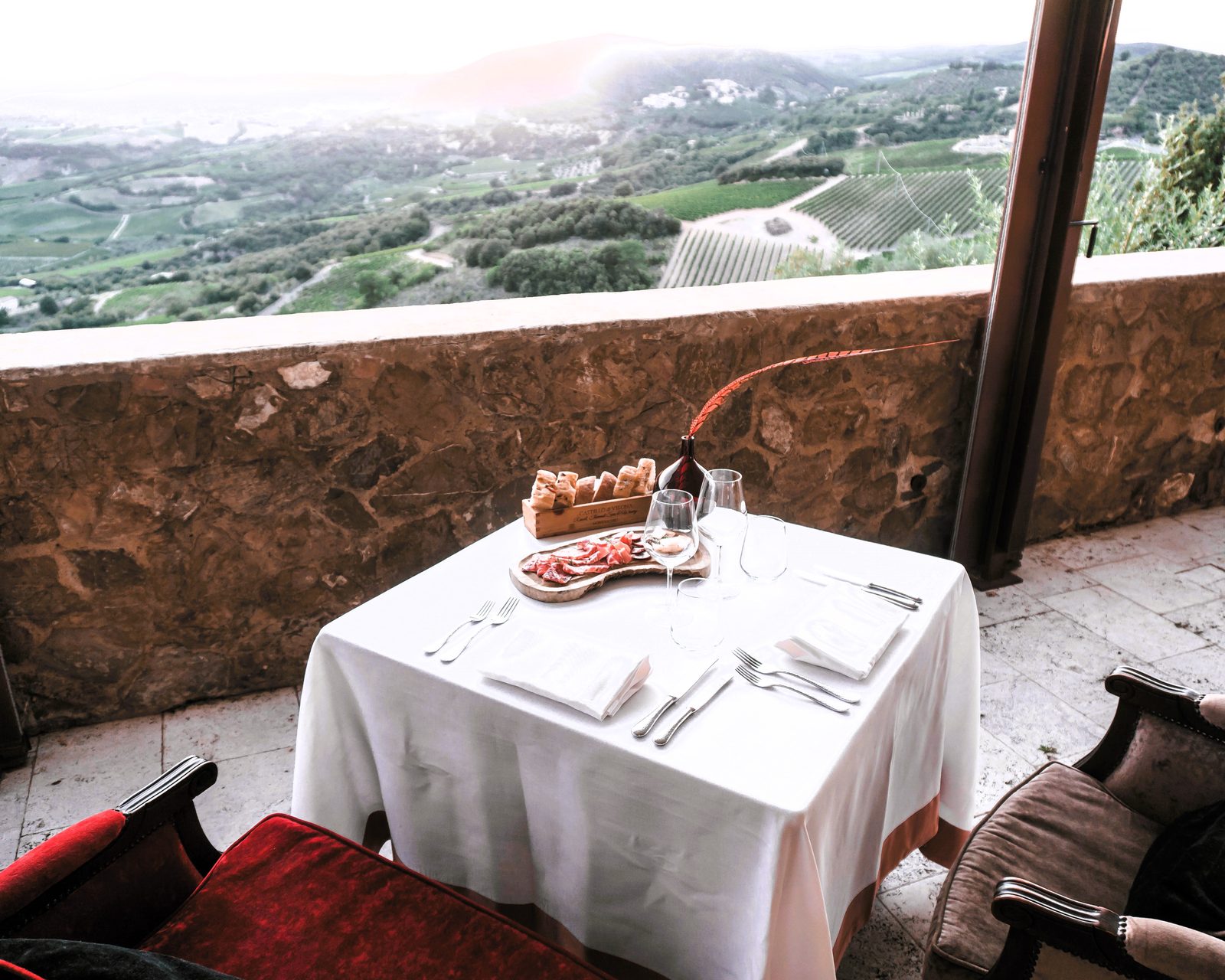 A table set on the terrace of Castello di Velona overlooking the Val d&rsquo;Orcia